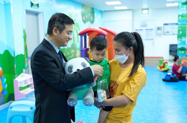 Ông Nguyễn Quang Trí – Giám đốc Điều hành Vinamilk, tặng quà cho các gia đình, các bé đến tiêm ngừa tại Trung tâm VNVC trong ngày kí kết hợp tác. Ảnh: Vi Nam