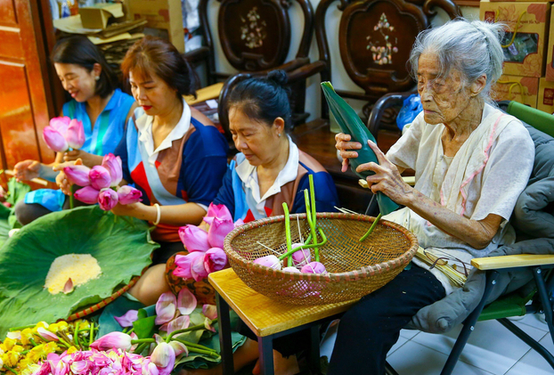 Cụ bà Nguyễn Thị Dần (bên phải) - mẹ bà Thân, năm nay đã 101 vẫn cùng con cháu tỉ mỉ ướp trà sen