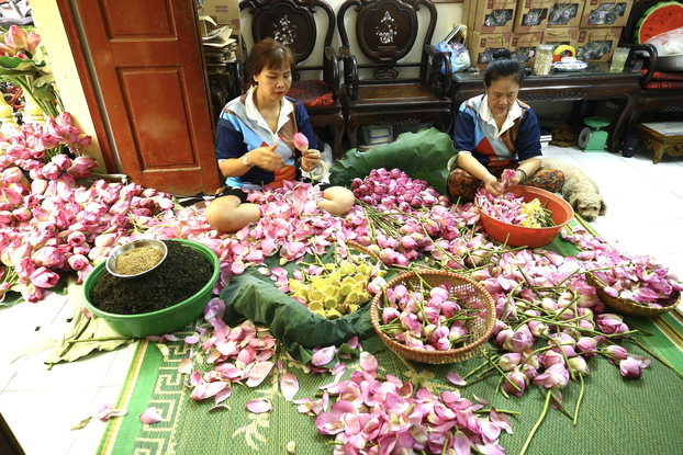 Bà Ngô Thị Thân (bên phải) đã gắn bó với nghề ướp trà sen từ bé