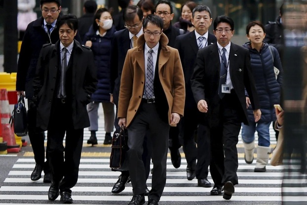 Người lao động băng qua đường tại một khu thương mại ở Tokyo, Nhật Bản. (Ảnh: Reuters)