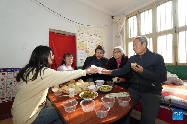 Cả gia đình Kong dùng bữa tại nhà ở làng Trung Doanh. (Ảnh: Tân Hoa Xã)