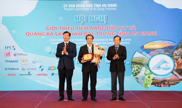 Ông Trần Tiến - Phó Tổng Giám đốc, Tổng Công ty Chăn nuôi heo nhận hoa và biểu trưng của UBND tỉnh An Giang cho các đơn vị có đóng góp phát triển kinh tế, xã hội của tỉnh