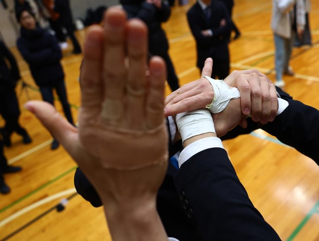 Bàn tay quấn băng và miếng dán giảm đau của các thành viên Cheer Re-Man’s trong buổi tập luyện tại Tokyo, Nhật Bản. Các thành viên thường đeo băng và dán miếng giảm đau vì thường xuyên bị đau cơ và bầm tím. Ảnh: REUTERS/Kim Kyung-Hoon