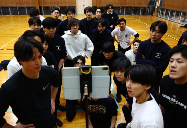 Các thành viên Cheer Re-Man’s xem lại video ghi hình buổi tập để đánh giá động tác tại Tokyo, Nhật Bản. Ảnh: REUTERS/Kim Kyung-Hoon
