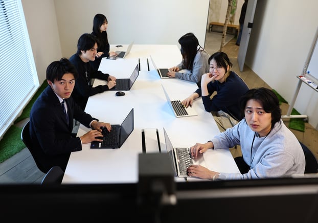 Soichiro Kakimoto (trái), 23 tuổi, thành viên nhóm Cheer Re-Man’s, tham dự cuộc họp cùng đồng nghiệp tại công ty Freakout, nơi phát triển phần mềm marketing ở Tokyo, Nhật Bản. Ảnh: REUTERS/Kim Kyung-Hoon
