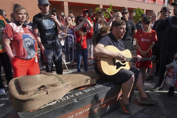 Một cổ động viên đánh guitar bài “You’ll never walk alone”, bài hát truyền thống của Liverpool FC, khi người hâm mộ tụ tập tưởng niệm Diogo Jota tại sân Anfield, sân nhà của Liverpool FC ở Liverpool, ngày 3/7. Ảnh: AP