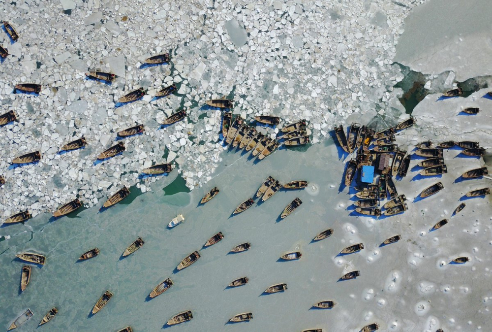     Hàng nghìn tàu cá ở cảng cá Jinshitan, tỉnh Liêu Ninh, Trung Quốc mắc kẹt trong băng. (Ảnh: Twitter)  