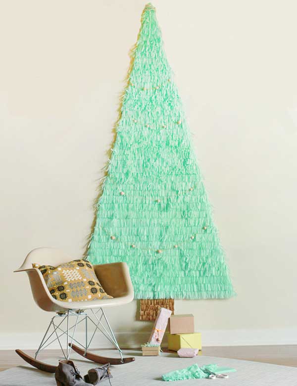 Chỉ cần dùng các mẩu giấy cắt tua rua, bạn cũng có thể dán một cây thông Noel lên tường nhà.