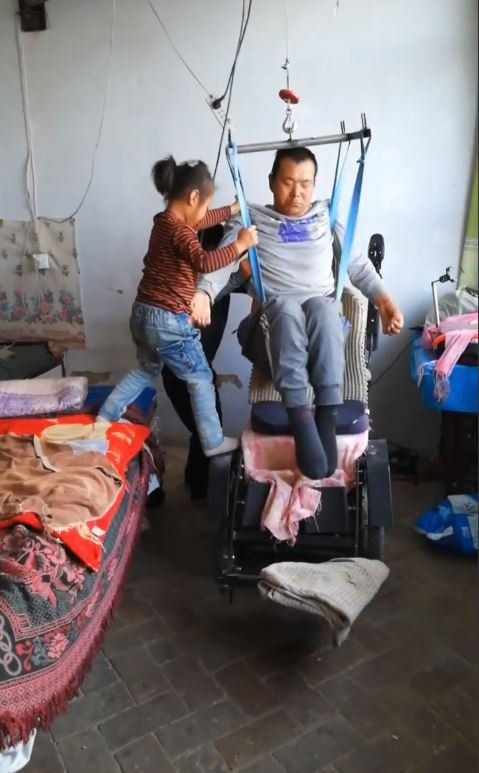   Bố cô bé đã bị liệt từ phần ngực trở xuống sau tai nạn thảm khốc 2 năm về trước - Ảnh: Kuaishou  