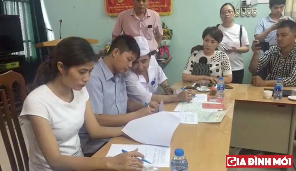 Gia đình chị Hương và anh Sơn ký biên bản bàn giao trẻ trước sự chứng kiến của đại diện lãnh đạo Sở Y tế Hà Nội sáng ngày 19/7