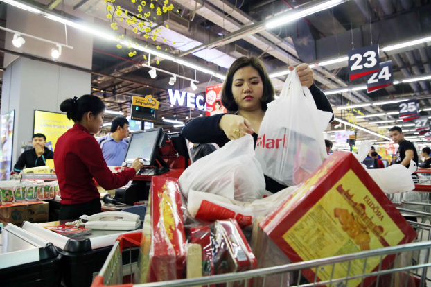   Ảnh chụp một người phụ nữ với xe đẩy hàng đầy ắp tại siêu thị VinMart Times City (Hà Nội).  