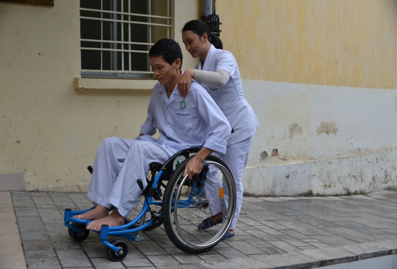 Nhân viên của Bệnh viện Bạch Mai hướng dẫn người bệnh sử dụng xe lăn