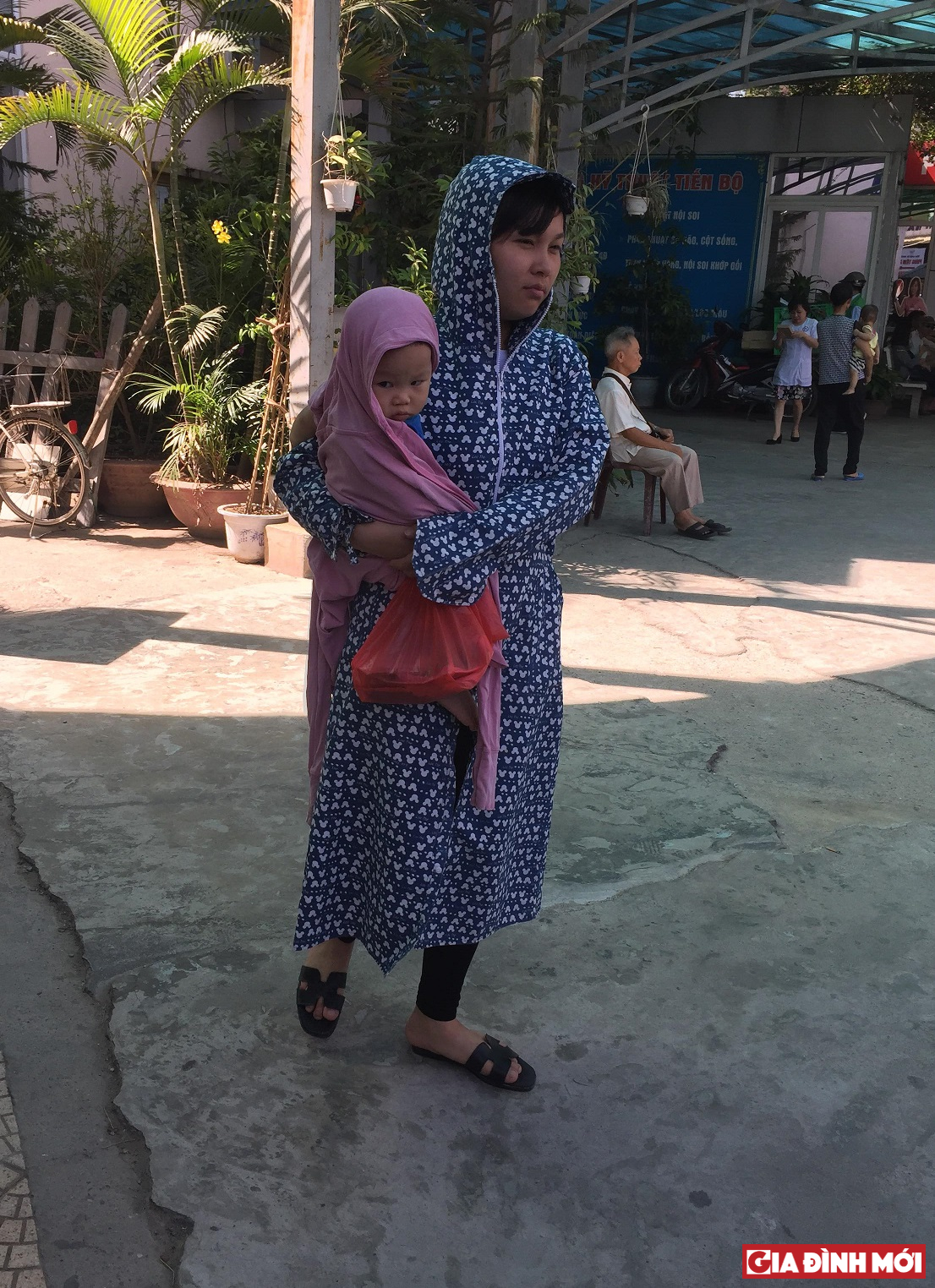 Mẹ và bé được bảo hộ kỹ càng khi đi viện ngày nắng nóng