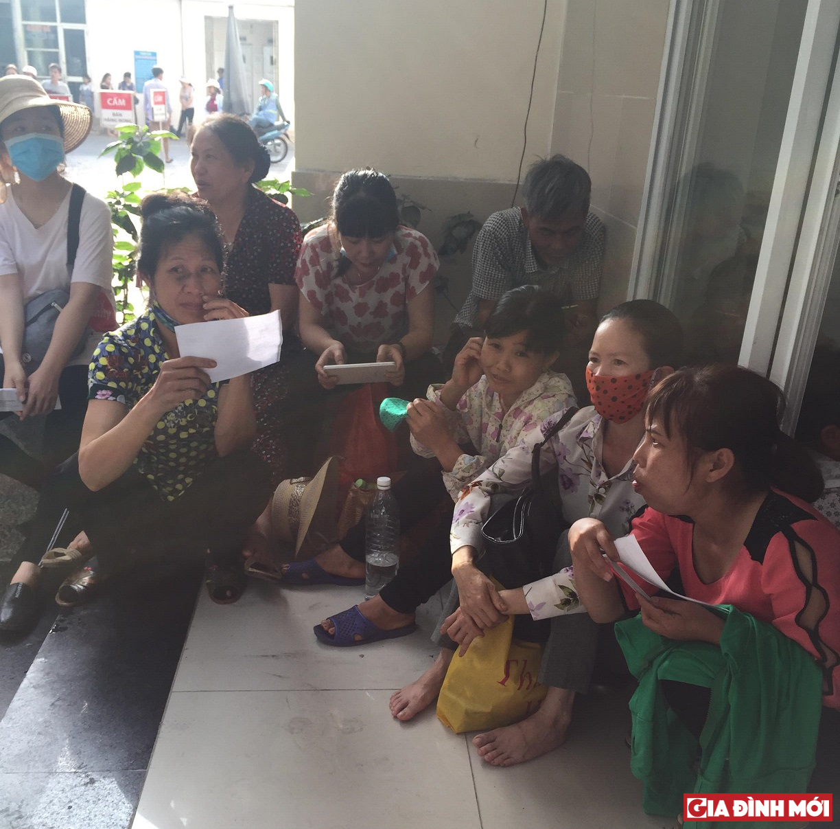 Người dân ngồi bệt ngoài hành lang tránh nắng và chờ đến lượt thăm khám