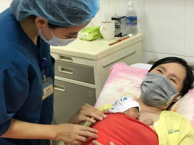   Nhân viên y tế đang hướng dẫn mẹ áp dụng phương pháp da kề da chăm sóc bé  