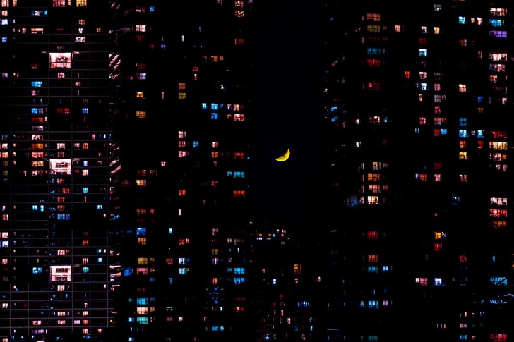 Mặt trăng treo giữa những tòa nhà trong thành phố