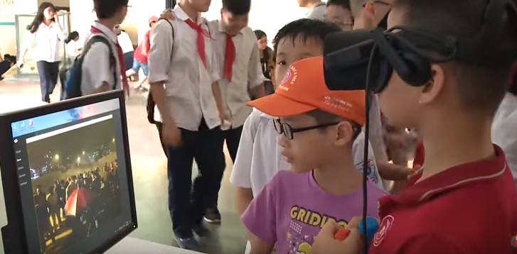 Các em nhỏ được nghe thuyết minh và xem hình ảnh 3D về văn hóa dân tộc thông qua kính thực tế ảo VR.