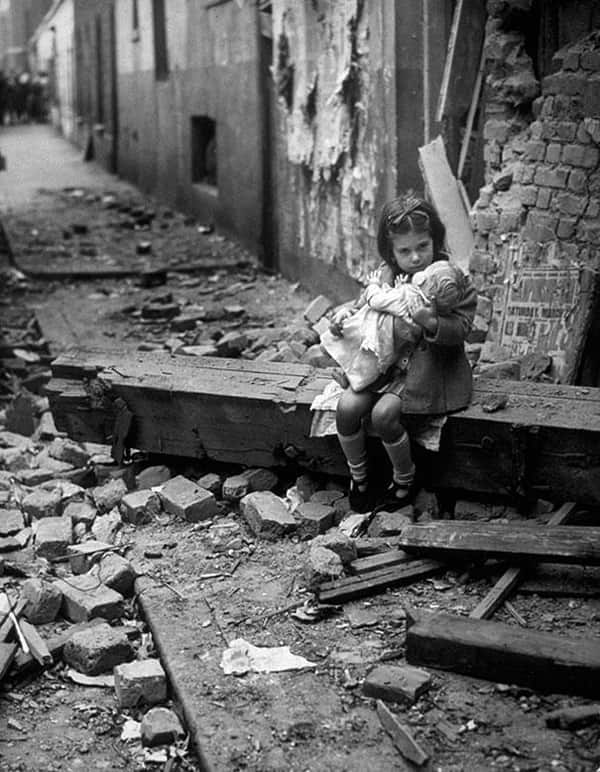 Cô bé nhỏ nhắn ngồi ôm con búp bê trên đống tàn tích của ngôi nhà bị đánh bom ở London vào năm 1940
