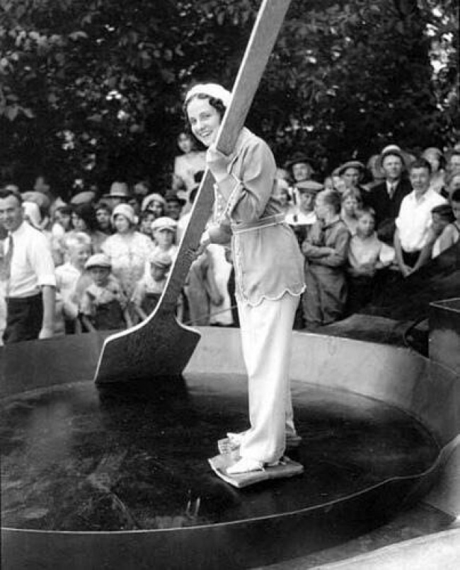 Một phụ nữ trong một cái chảo chiên khổng lồ với thịt xông khói được buộc vào chân trước khi 7.200 quả trứng được thêm vào để hoàn thành món trứng tráng kỷ lục tại Hoa Kỳ năm 1931