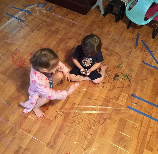 Hoặc với các con thích vẽ trên sàn nhà, dùng tấm nhựa lớn trải lên sàn để con thỏa thích quậy