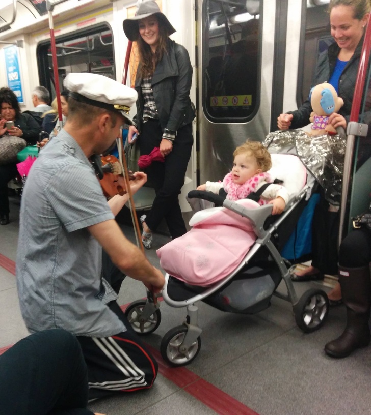 Người đàn ông chơi violin trên suốt chuyến tàu điện để dỗ bé gái nín khóc