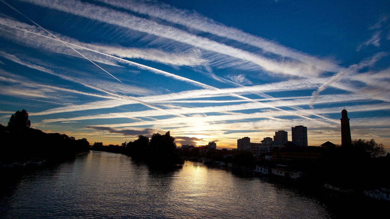 Mạng lưới giao thông hàng không toàn cầu dày đặc, đặc biệt là hàng không thương mại, là nguyên nhân chính gây ra ô nhiễm không khí, phát thải khí nhà kính. Trong hình bạn có thể thấy những vệt khói sau máy bay chồng chéo, dày đặc trên bầu trời London, ngay trên dòng sống Thames.