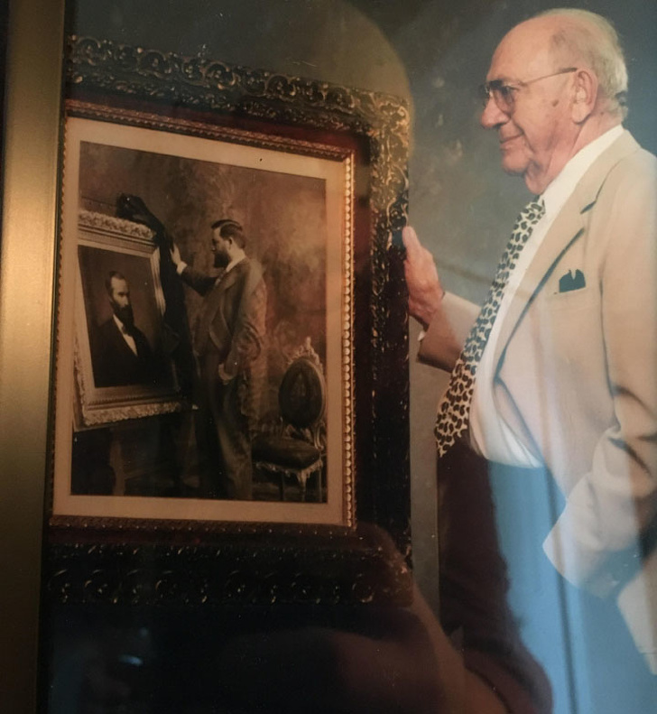 Bức ảnh ông nội của tôi đang đứng cạnh bức ảnh ông nội của ông đang đứng cạnh ông nội của ông ấy.