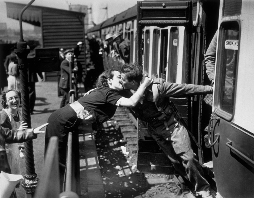   Cô gái vươn người qua hàng rào chắn để hôn người lính Anh trở về từ Thế chiến II, London, Anh, 1940  