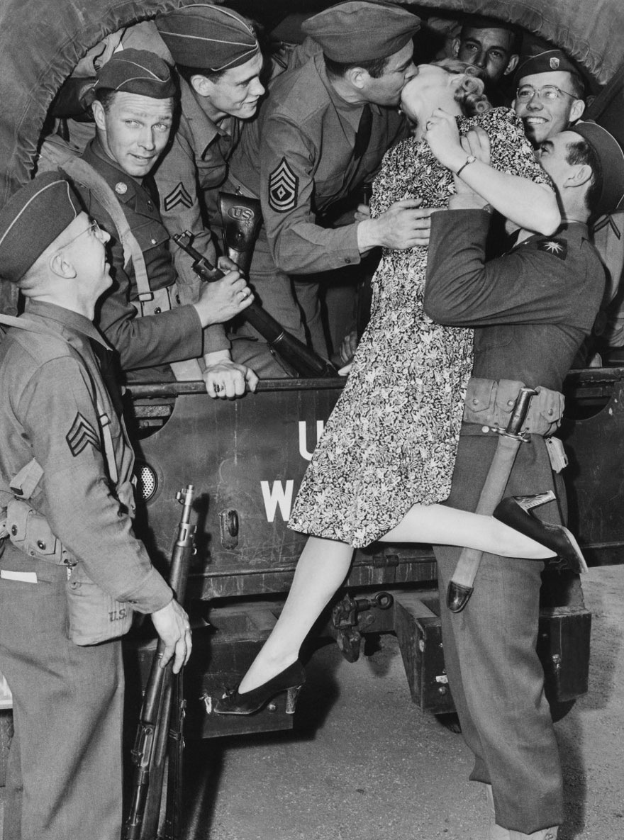   Nữ diễn viên Martha O’driscoll hôn tạm biệt một người lính ở Los Angeles, Mỹ năm 1941 với sự giúp đỡ của những người đồng đội  