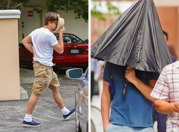   Leonardo DiCaprio chụp cả ô lên đầu để che mặt  