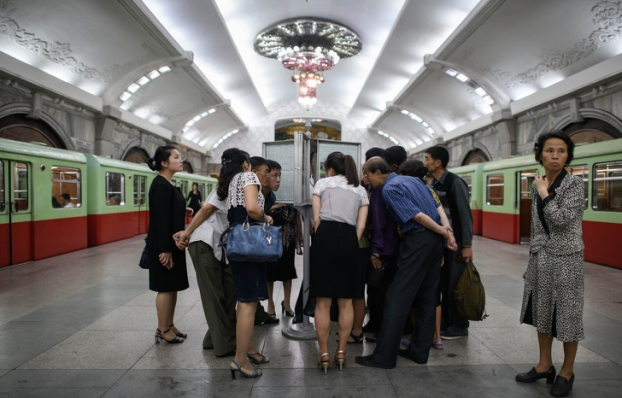   Người dân Bình Nhưỡng đang đọc báo ở ga tàu điện ngầm về cuộc gặp gỡ của Kim Jong-un và Donald Trump. Những chiếc tàu điện ngầm được sản xuất ở Đức giữa thế kỷ XX và chuyển đến Triều Tiên vào những năm 1990  