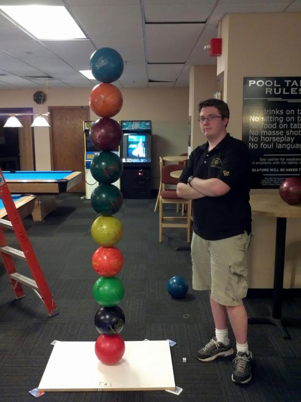   Chàng trai xếp những quả bóng bowling  