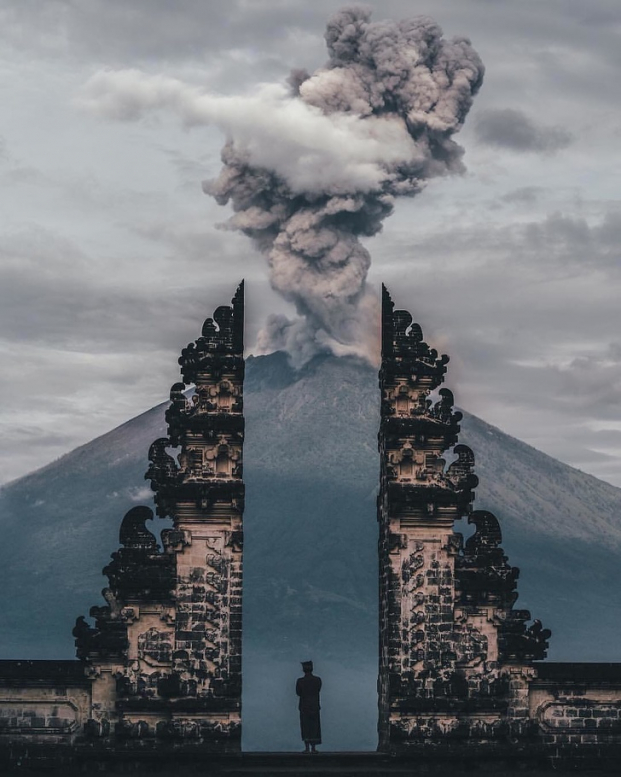   Người coi đền ở Bali đang nhìn ngọn núi lửa phun trào  