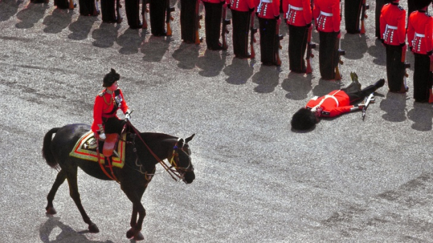   Một người lính bị ngất khi Nữ hoàng Elizabeth II cưỡi ngựa đi qua trong một cuộc diễu hành vào tháng 6/1970.  