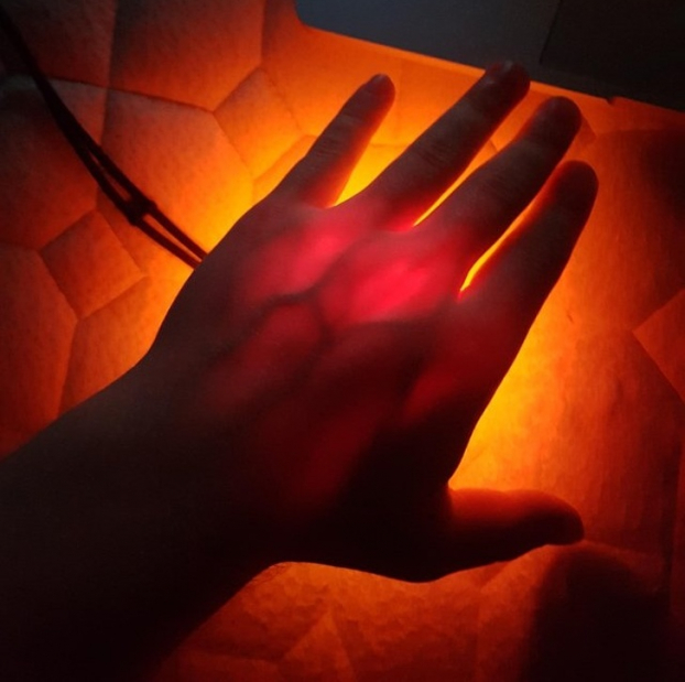   Ánh đèn flash 4.000 lumen chiếu qua bàn tay tôi  