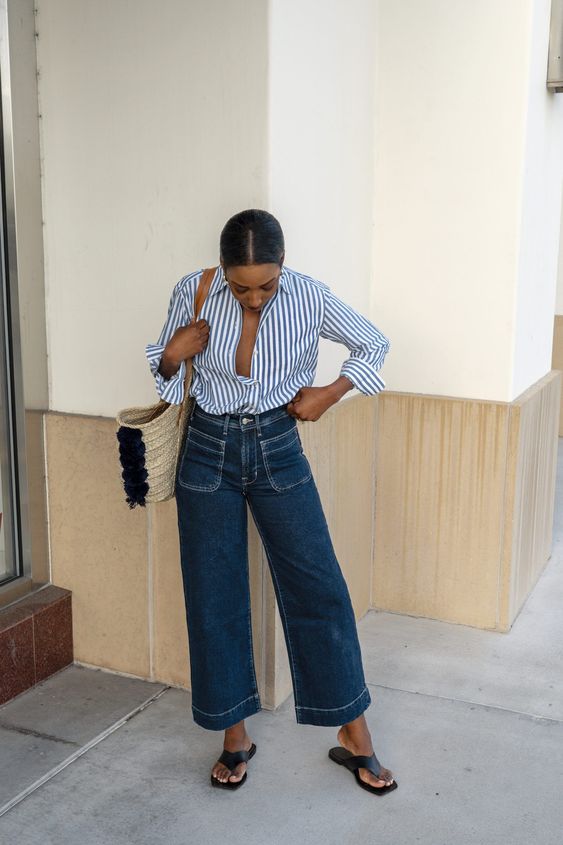 a blue striped shirt, navy jeans with pockets and a straw bag are a lovely combo for spring and cold summer days