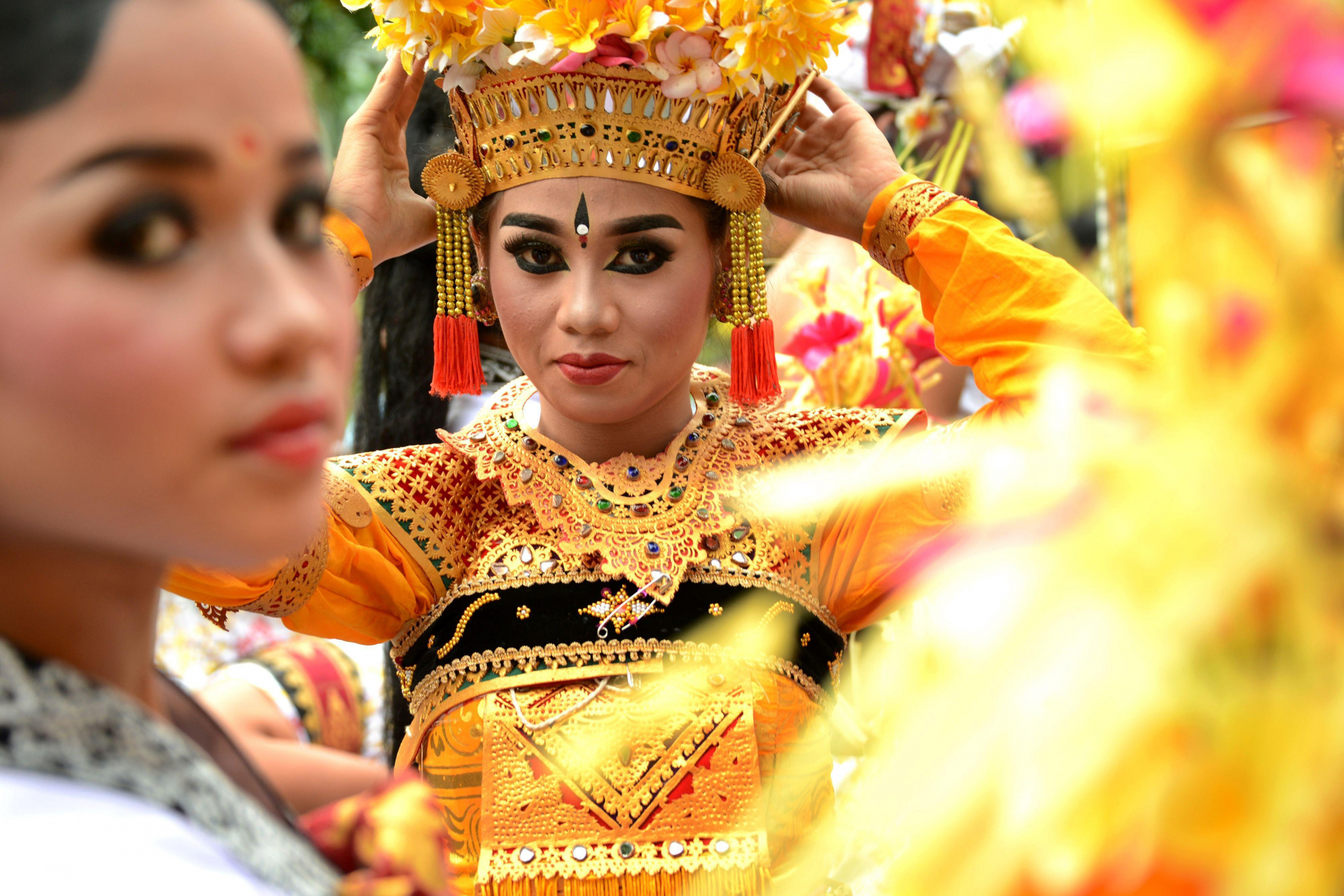 Một vũ nữ người Bali đang chỉnh lại mũ đội để chuẩn bị cho màn diễu hành chào năm mới