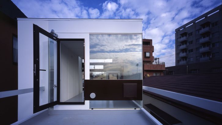 Một ngôi nhà theo phong cách công nghiệp được thiết kế bởi công ty của KTS Yamashita, Atelier Tekuto, sử dụng bê tông cốt thép, thép và kính phản quang 