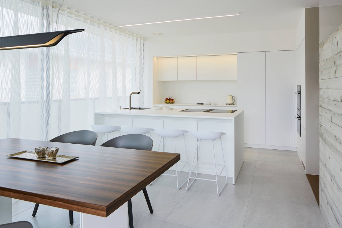 Khi áp dụng phong cách tối giản, sự kết hợp của màu trắng và gỗ không bao giờ lỗi mốt. Với căn bếp này, màu trắng khiến cho chiếc bàn ăn gỗ đỏ trở nên nổi bật hơn. 