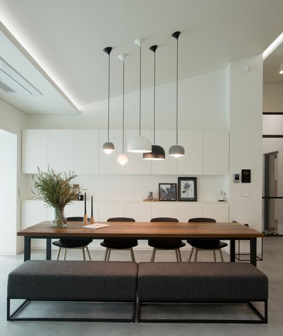 Tủ bếp tối giản màu trắng và chiếc bàn ăn bằng gỗ màu sẫm cùng với băng ghế tạo ra một không gian vô cùng lãng mạn