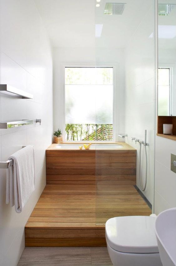 Bồn tắm bằng gỗ và sàn nhà được lát gỗ cùng màu, kết hợp với tường và các thiết bị vệ sinh màu trắng mang lại sự lãng mạn, nhẹ nhàng