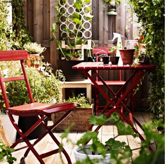 Khu vườn mùa xuân đầy màu xanh. Bộ bàn ghế gỗ màu đỏ làm cho không gian thêm sinh động và thú vị