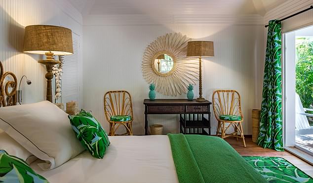 Họa tiết hình cây cọ trên rèm cửa, thảm trải sàn và vỏ gối cùng những điểm nhấn màu xanh lá cây tạo một vẻ tươi mát và sống động cho căn phòng ngủ