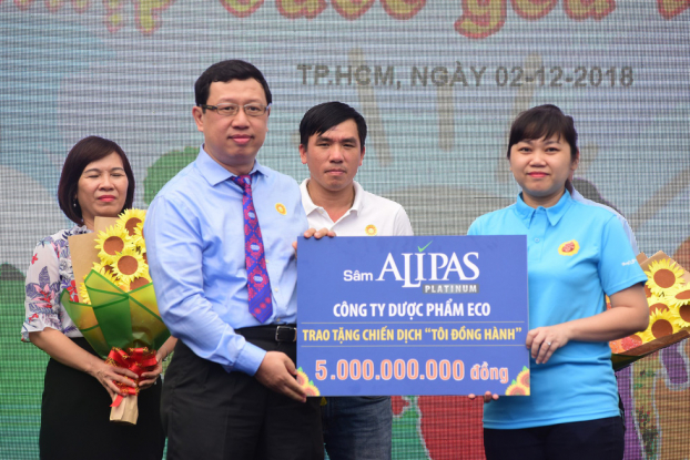   Đại diện công ty dược phẩm Eco (trái) trao tượng trưng 5 tỉ đồng cho chiến dịch 'Tôi đồng hành' tại Ngày hội hoa hướng dương 2-12 - Ảnh: Tuổi trẻ  