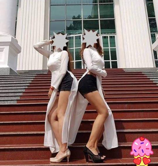   2 nữ sinh viên mặc áo dài trắng phối với quần đùi ngắn cũn cỡn, ưỡn ngực chu mông chụp ảnh.  