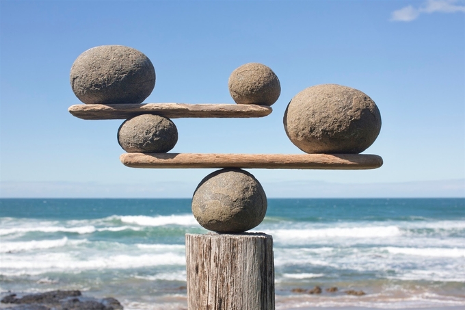 rocks-balancing-on-driftwood-sea-in-background