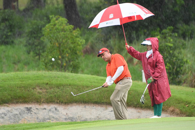 Các golfer thi đấu trong điều kiện thời tiết mưa
