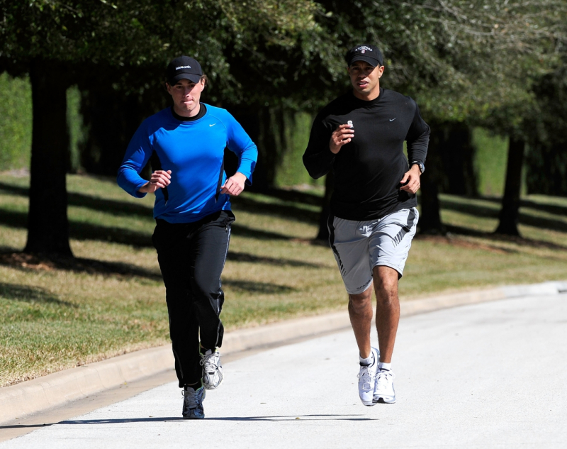 Tiger Woods (phải) tập luyện chạy bộ mỗi ngày
