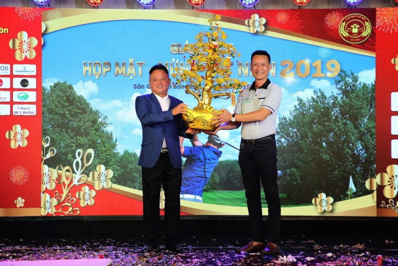 Ông Nguyễn Chí Hùng (trái), Chủ tịch CLB Golf Hà Nội - Sài Gòn trao vật phẩm đấu giá từ thiện Cây mai vàng cho đại diện Công ty Chiêu Thanh