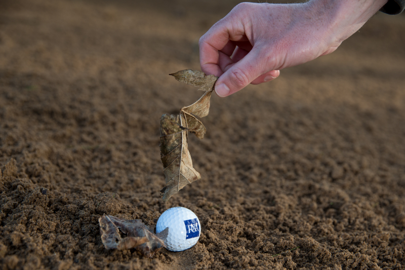 Golfer được phép loại bỏ những vật thể rời ở trong bunker, miễn là không làm bóng di chuyển nhưng tuyệt đối không được chạm cát bằng tay hoặc gậy golf (Ảnh: R&A)
